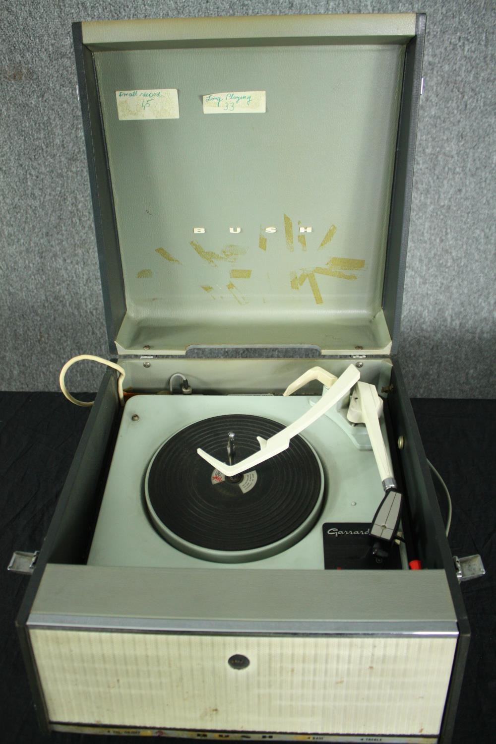 A vintage portable turntable / record player, Garrard in a Bush case. H.24 W.38 D.44cm.