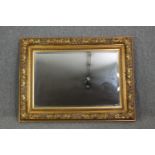 A giltwood and gesso wall mirror with foliate decoration and bevelled plate. H.91 W.120cm.