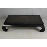 A Chinese style black lacquered low coffee table (missing glass), H.38 W.140 D.95cm.