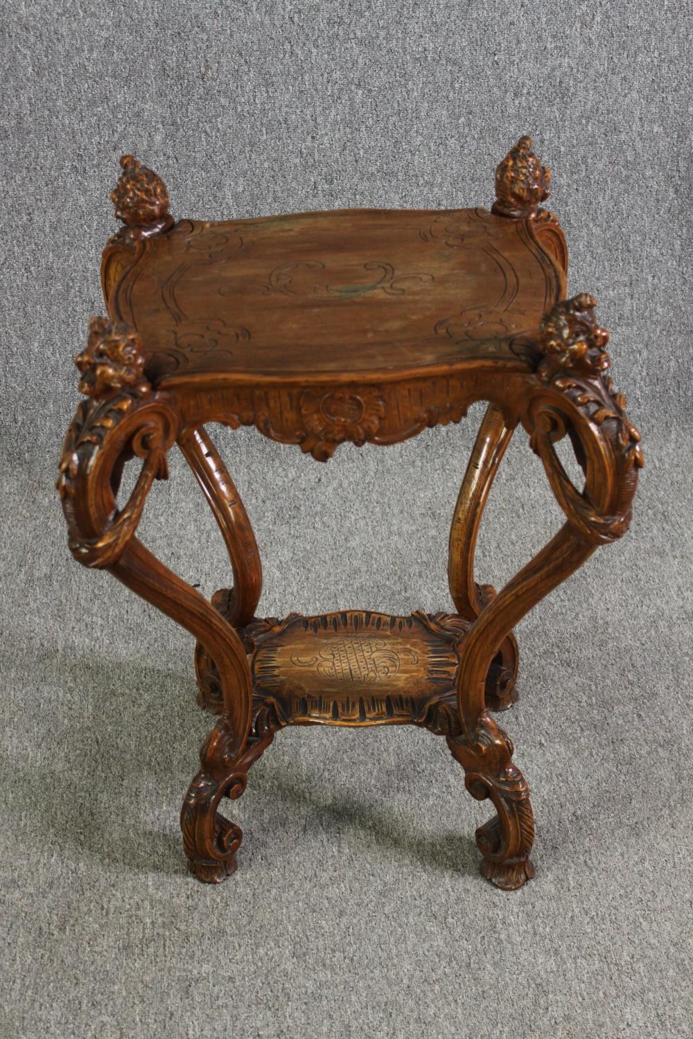 A French Rococo style carved walnut side table on mask carved cabriole supports, 19th century. H.