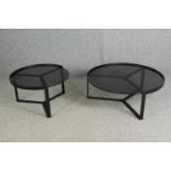 Two contemporary coffee tables with tinted glass tops and black metal supports. H.35 Dia.89cm. (