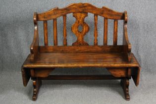 A Continental walnut bench with (unusual) drop flaps to each end. H.105 W.107 D.51cm.