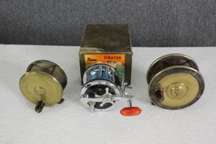 Two antique brass fishing reels, one by Charles Farlow, and a steel reel by Penn Senator, Dia.