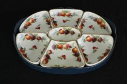 A set of Wedgwood Imperial porcelain serving dishes decorated with botanical fruits, within a fitted
