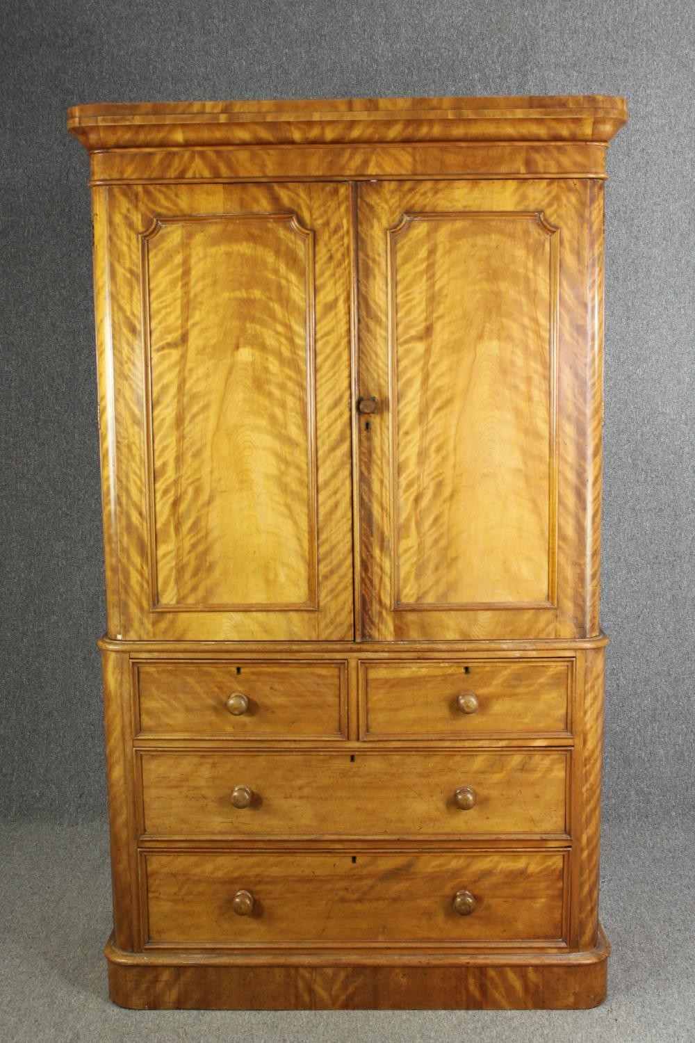 A Victorian satinwood linen press, fitted with slides above drawers on a plinth base. H.205 W.115