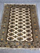Carpet, Bokhara style, repeating motifs on an ivory ground within flowerhead multiple borders. L.183