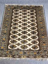 Carpet, Bokhara style, repeating motifs on an ivory ground within flowerhead multiple borders. L.183
