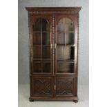 An oak bookcase, mid 20th century, one glass pane is missing. H.209 W.115 D.36cm.