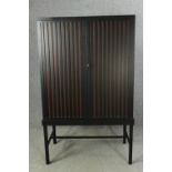 A contemporary ebonized cabinet on stand. H.169 W.102 D.60cm.