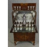 An Art Deco burr walnut cocktail cabinet, circa 1930, enclosing various cut drinking glasses and a