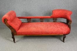 A late Victorian carved walnut chaise longue, with red damask upholstery, H.78 W.180 D.53cm.