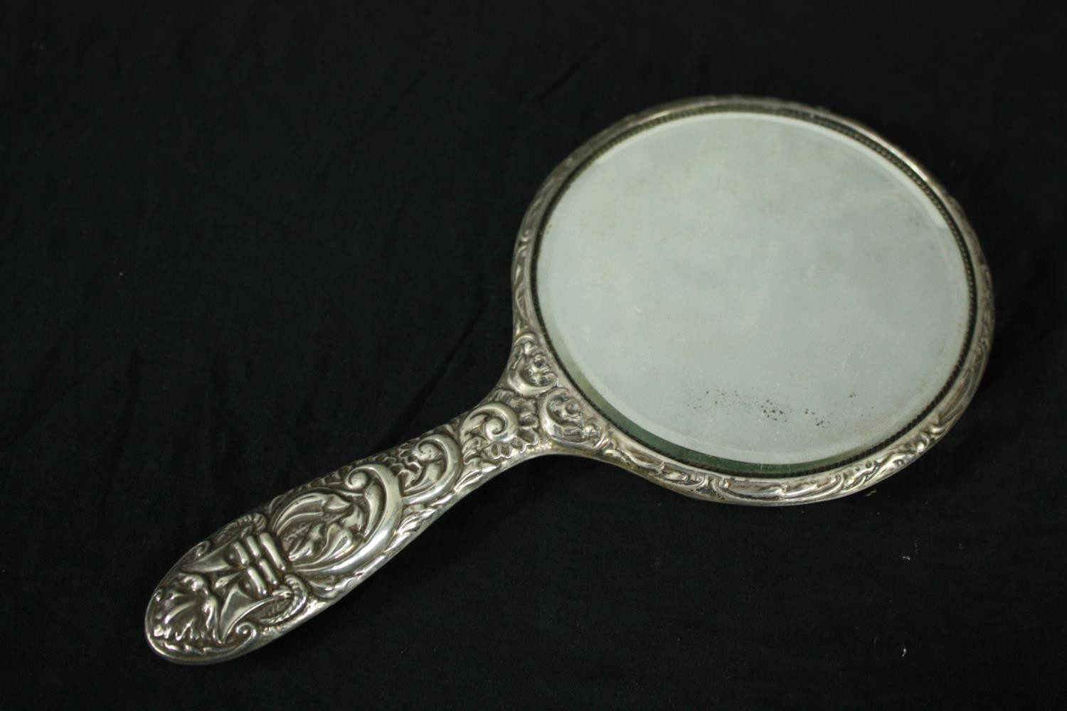 A silver repousse dressing set with foliate and floral design. A mirror and two brushes. Hallmarked: - Image 4 of 5
