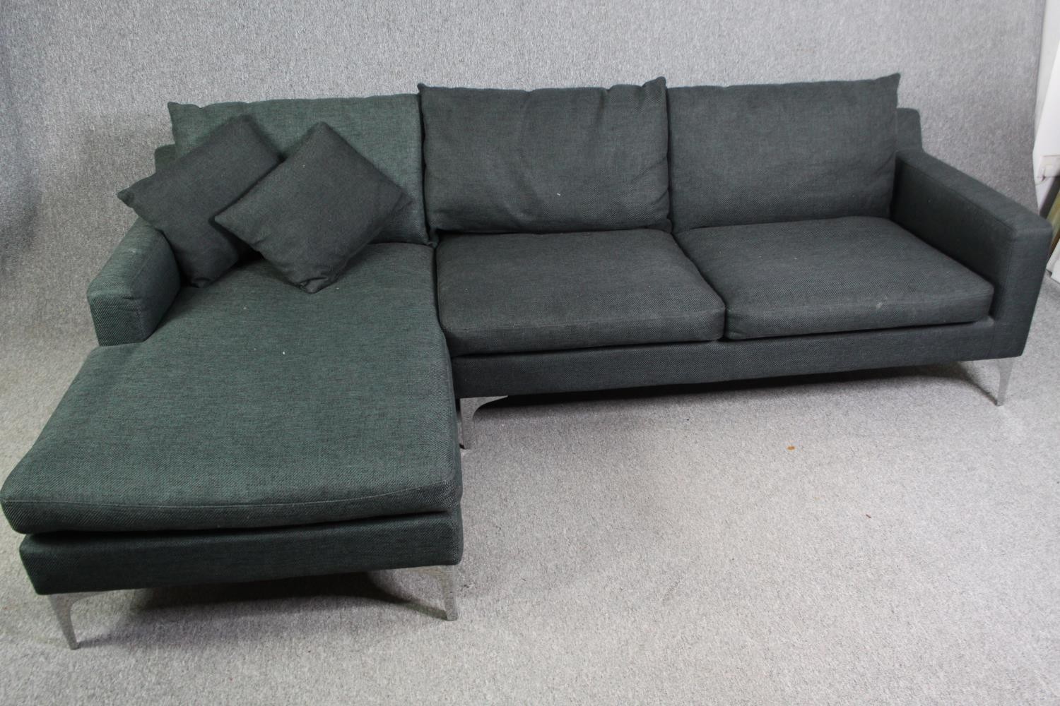 A contemporary grey upholstered corner sofa with chrome supports, H.80 W.246 D.150cm.