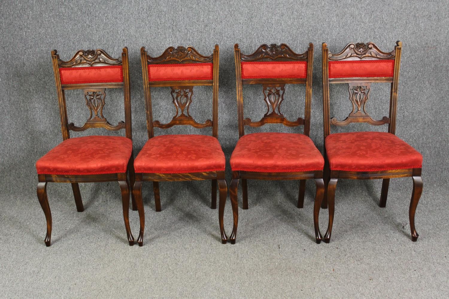 A set of four late Victorian walnut salon chairs in red damask upholstery