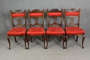 A set of four late Victorian walnut salon chairs in red damask upholstery