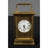 A St James London brass carriage clock with white enamel dial and black roman numerals. With key.