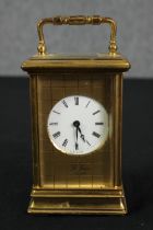 A St James London brass carriage clock with white enamel dial and black roman numerals. With key.