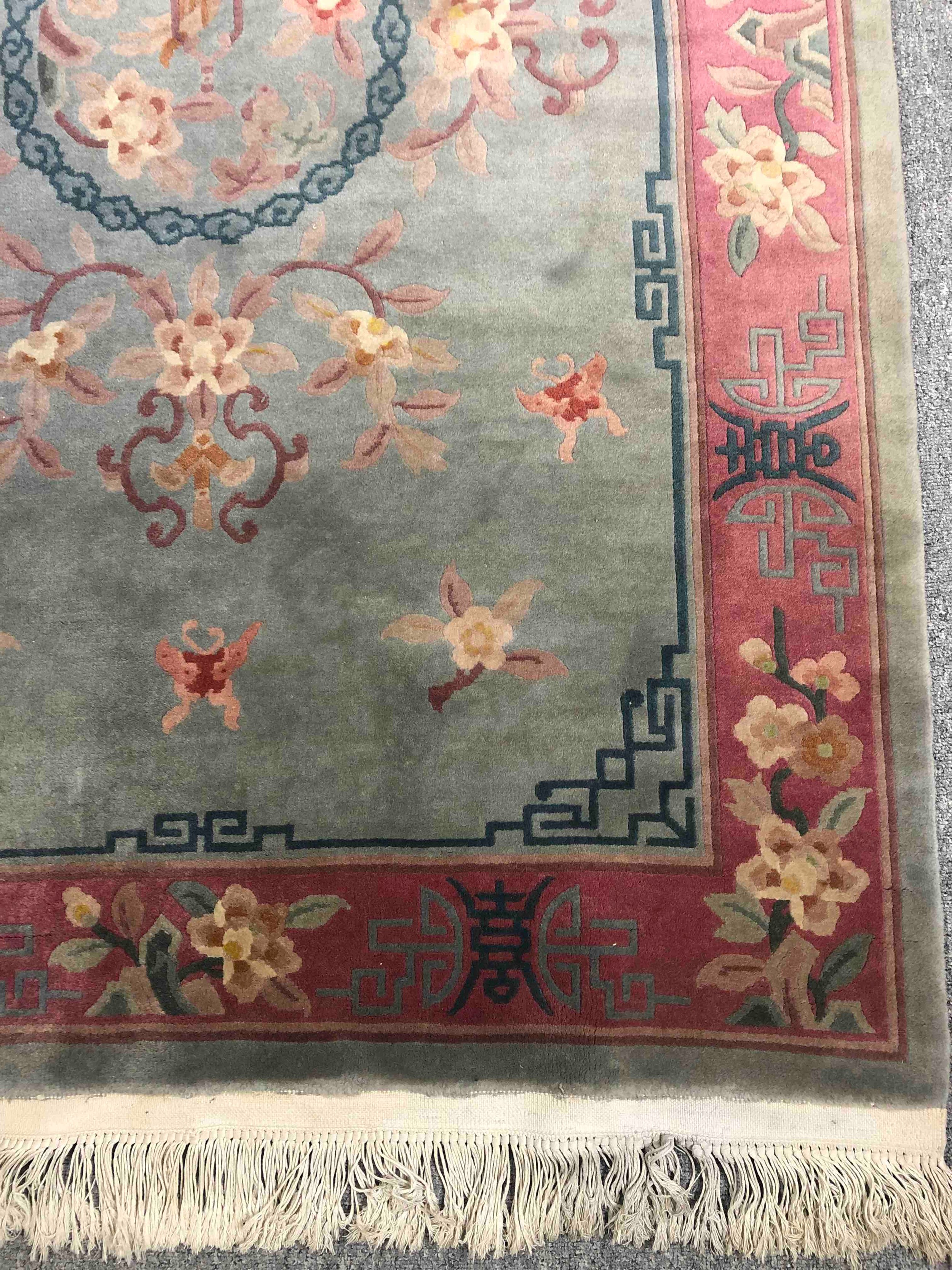A Chinese woollen carpet with central flowerhead medallion within complementary burgundy borders. - Image 2 of 4