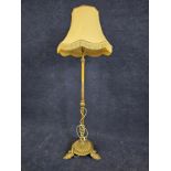 A brass standard lamp, on leaf supports. H.146cm.