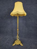 A brass standard lamp, on leaf supports. H.146cm.