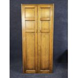 A narrow oak wardrobe, first half 20th century with maker's label. H.73 W.76 D.40cm.