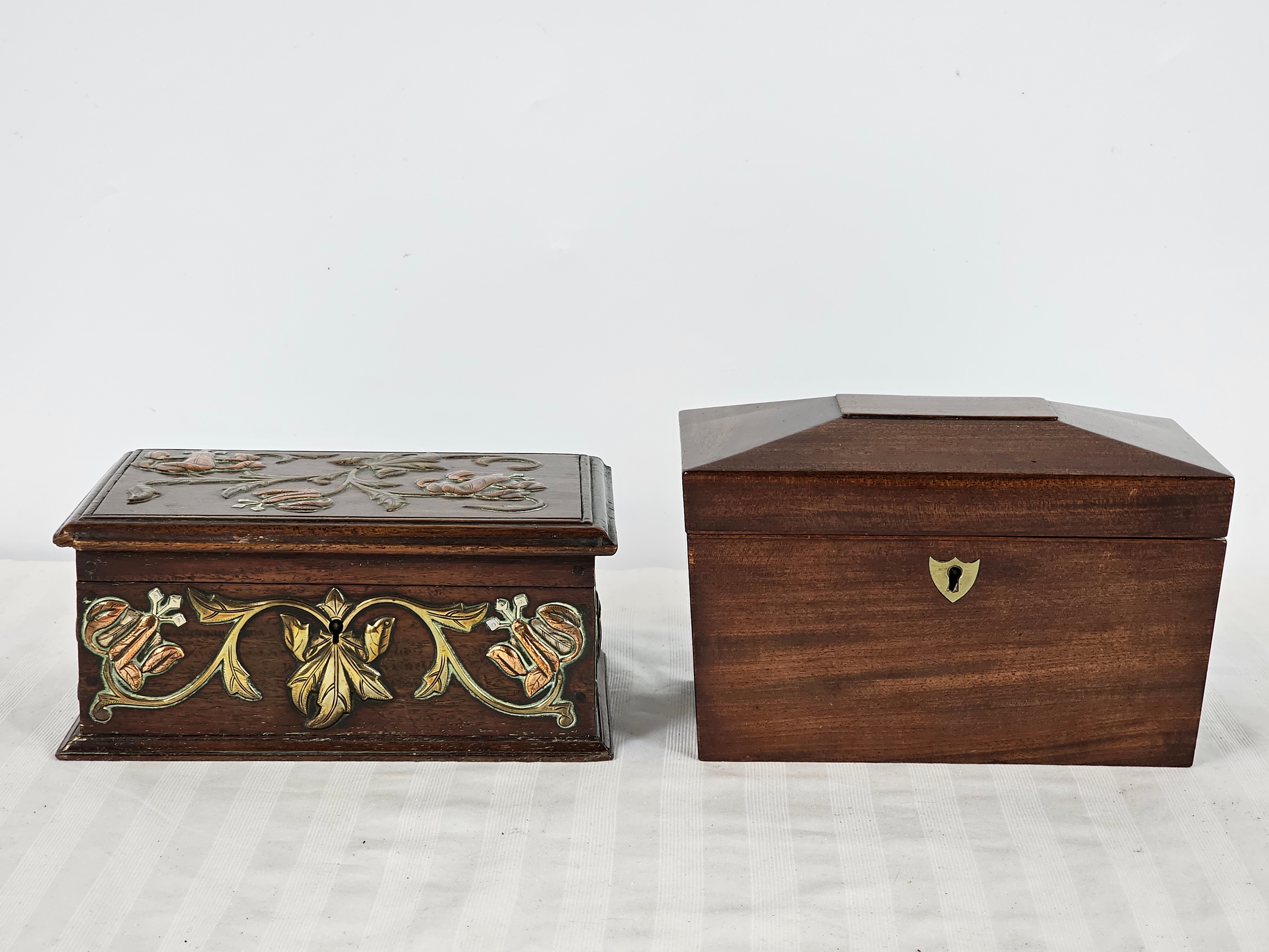 A 19th century mahogany tea caddy, and an Arts and Crafts box with brass and copper repousse