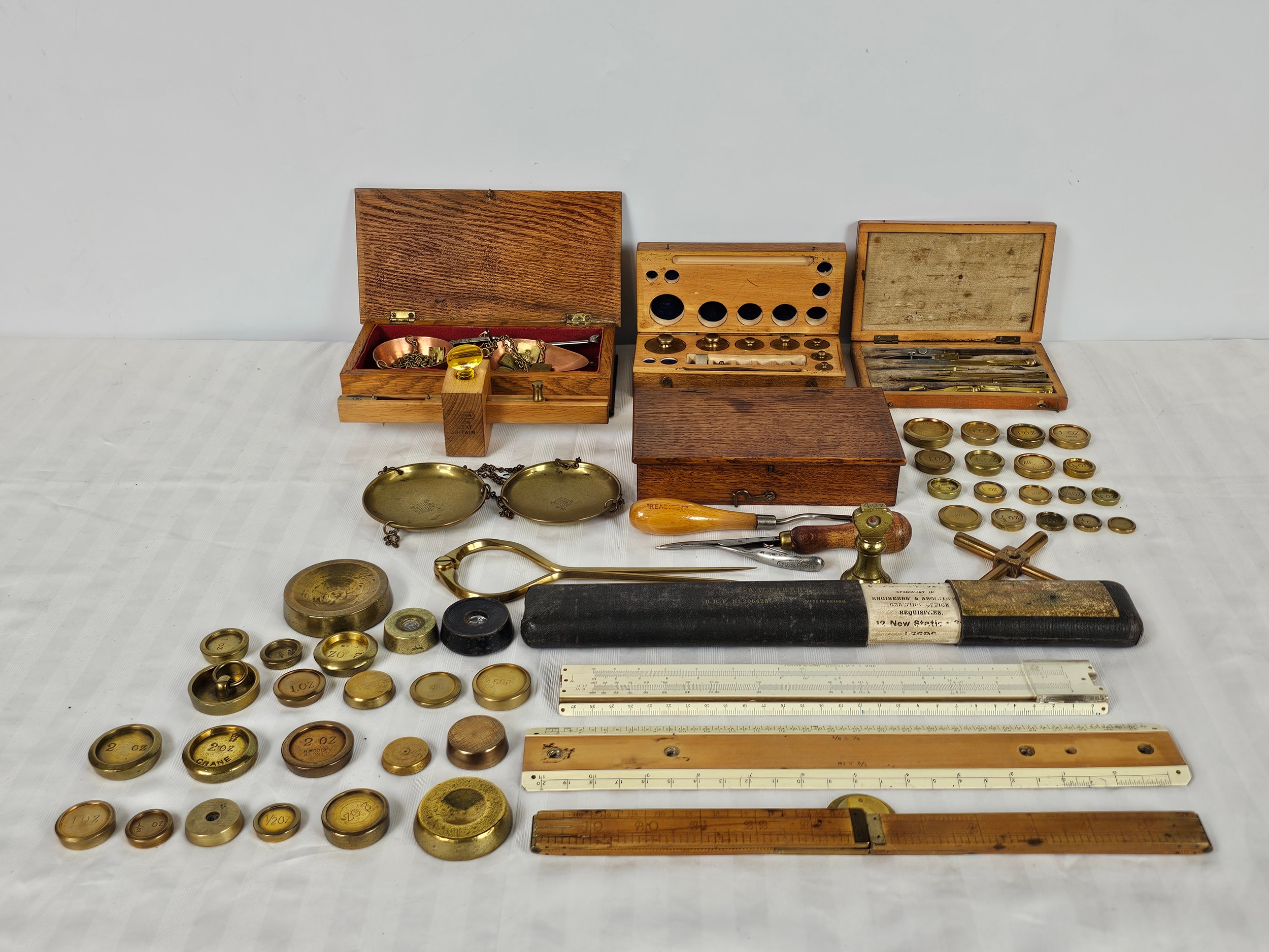A large group of vintage brass weights, draughtman's geometry set, scales and rules
