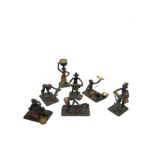 Seven miniature African tribal painted metal figures depicting various everyday activities.