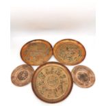 A collection of five early 20th century Persian copper repousse dishes, including a pair of coasters