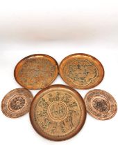 A collection of five early 20th century Persian copper repousse dishes, including a pair of coasters