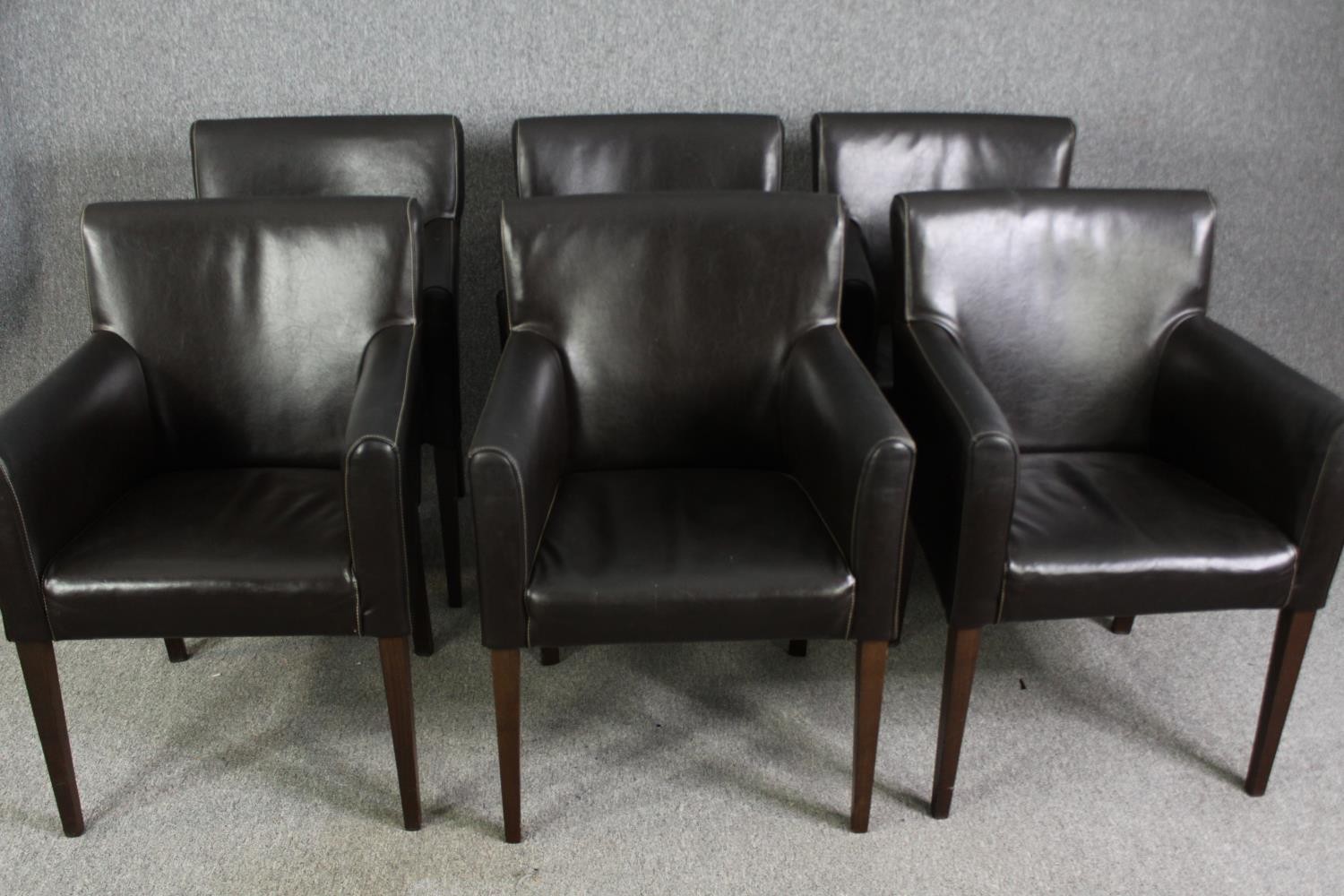 A set of six leatherette upholstered dining chairs.