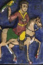 A Persian Qajar pottery tile, depicting a figure on horseback. H.19 W.14cm.