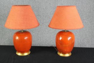 A pair of mid 20th century orange glazed table lamps. H.40cm. (each).