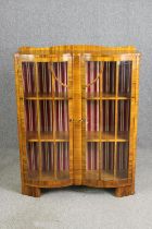 An Art Deco double bow fronted walnut display cabinet. H.126 W.100 D.32cm.