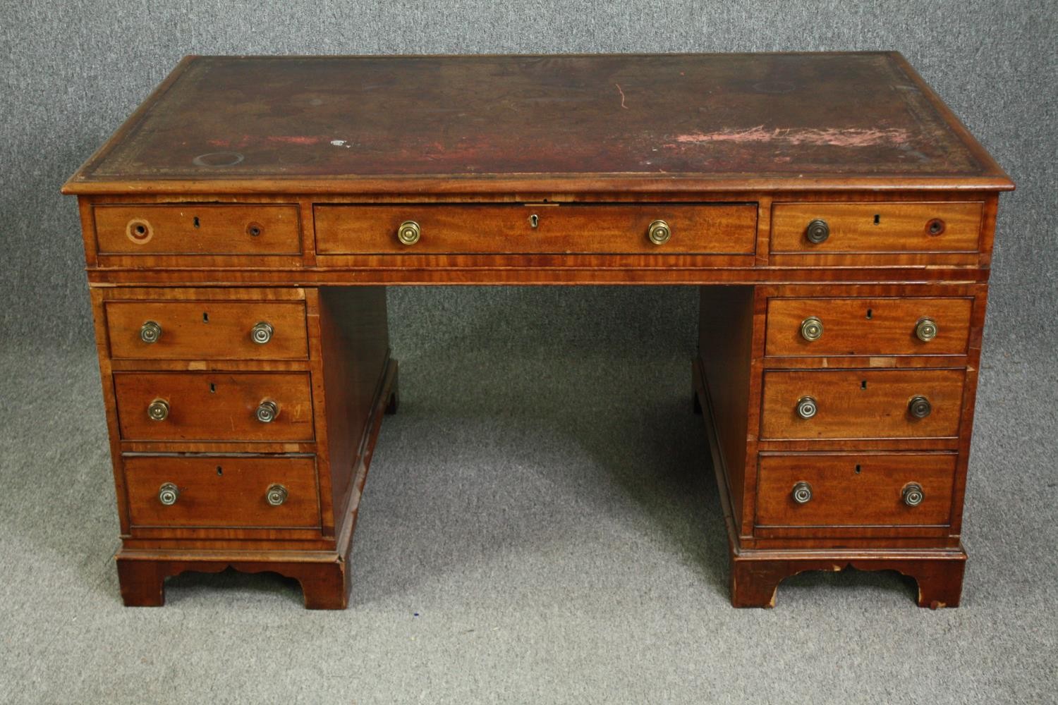 An early Victorian mahogany pedestal desk, with tooled red leather top and matching fitted leather