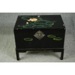 A Chinese black lacquered travelling chest on stand, hand decorated with peonies, early 20th