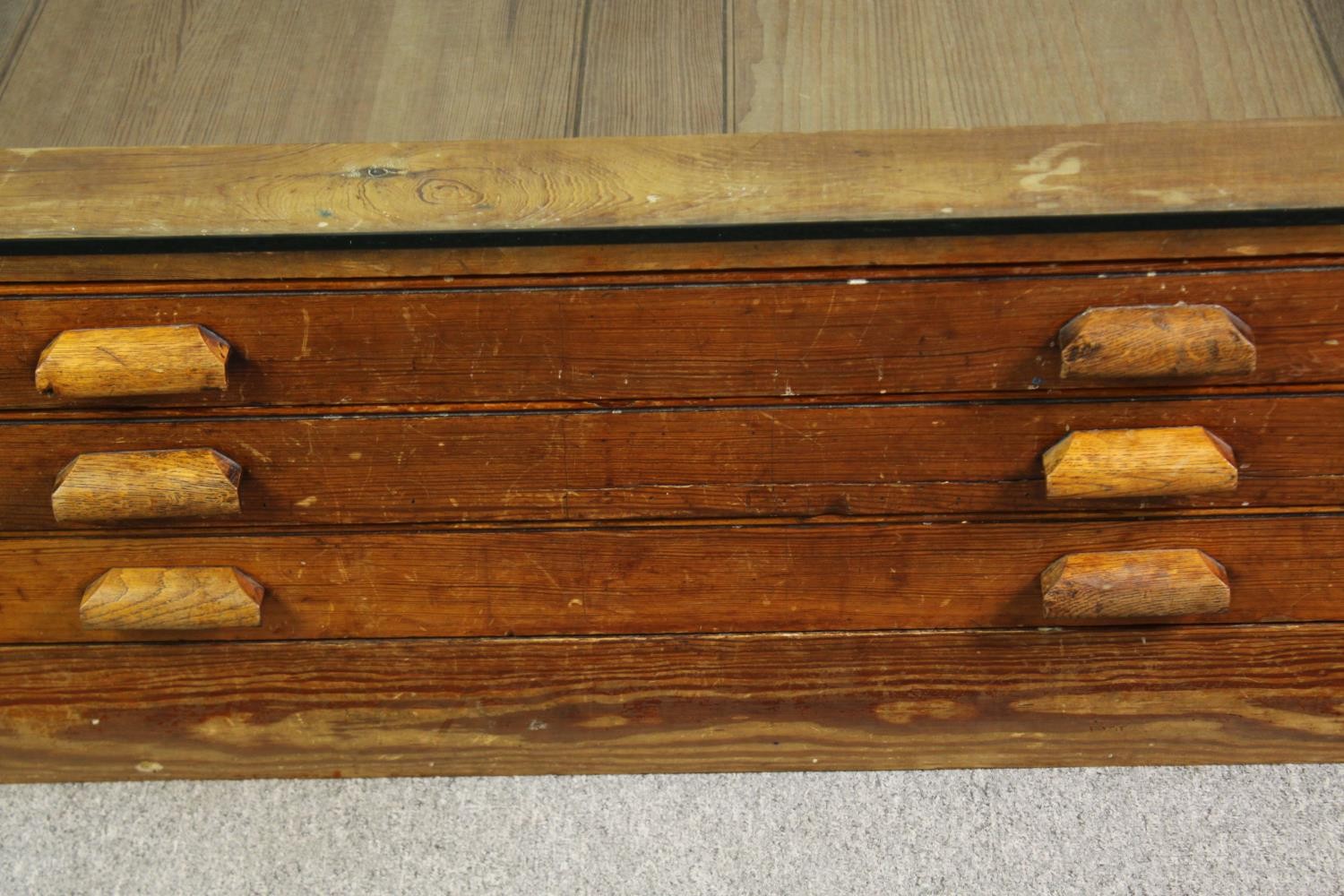 A 1920's pine planners chest, with later glass top to form a coffee table. H.40 W.123 D.92cm. - Image 8 of 8
