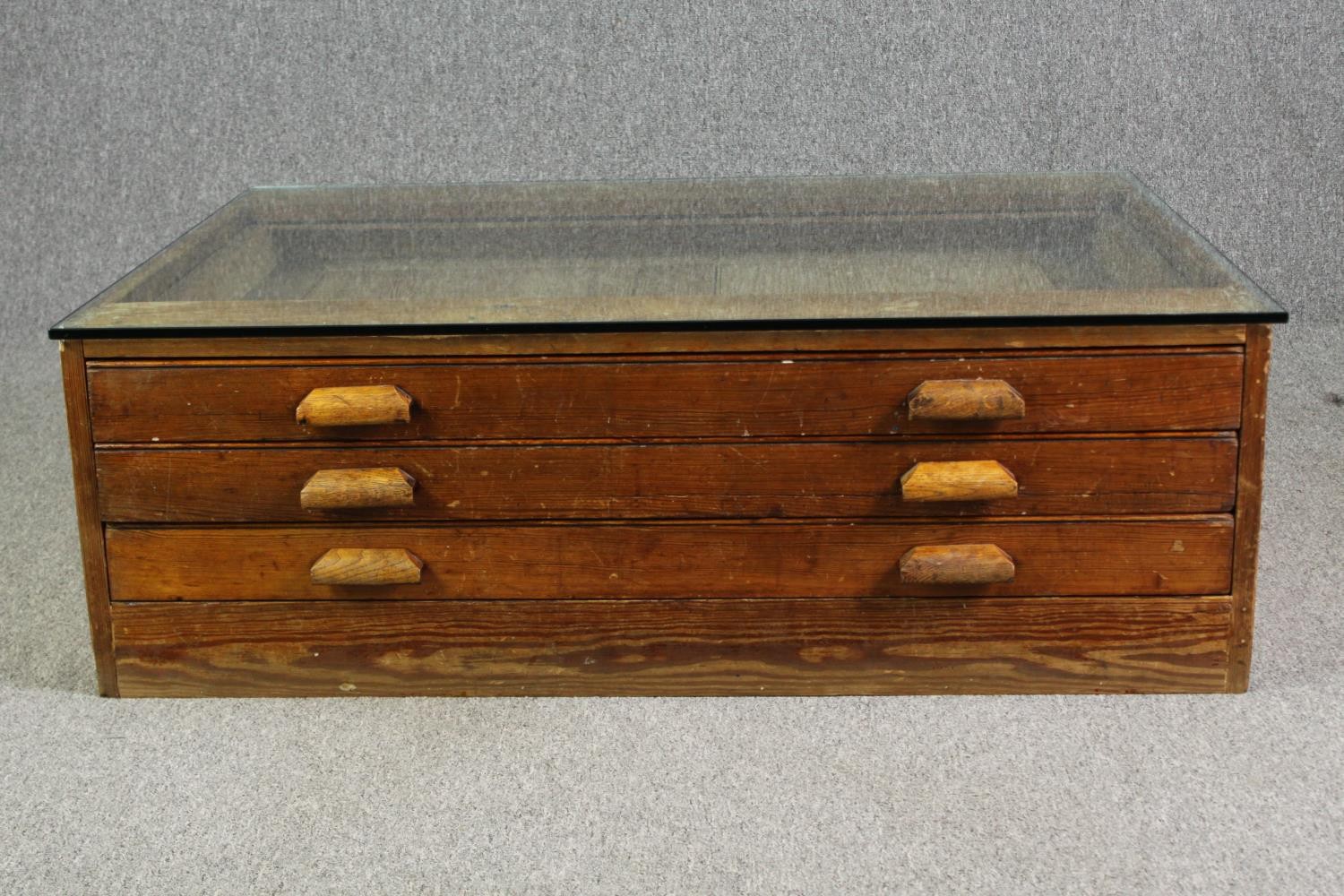 A 1920's pine planners chest, with later glass top to form a coffee table. H.40 W.123 D.92cm. - Image 2 of 8