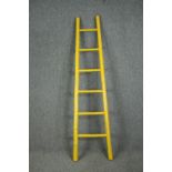 A yellow painted bamboo ladder. H.197cm.