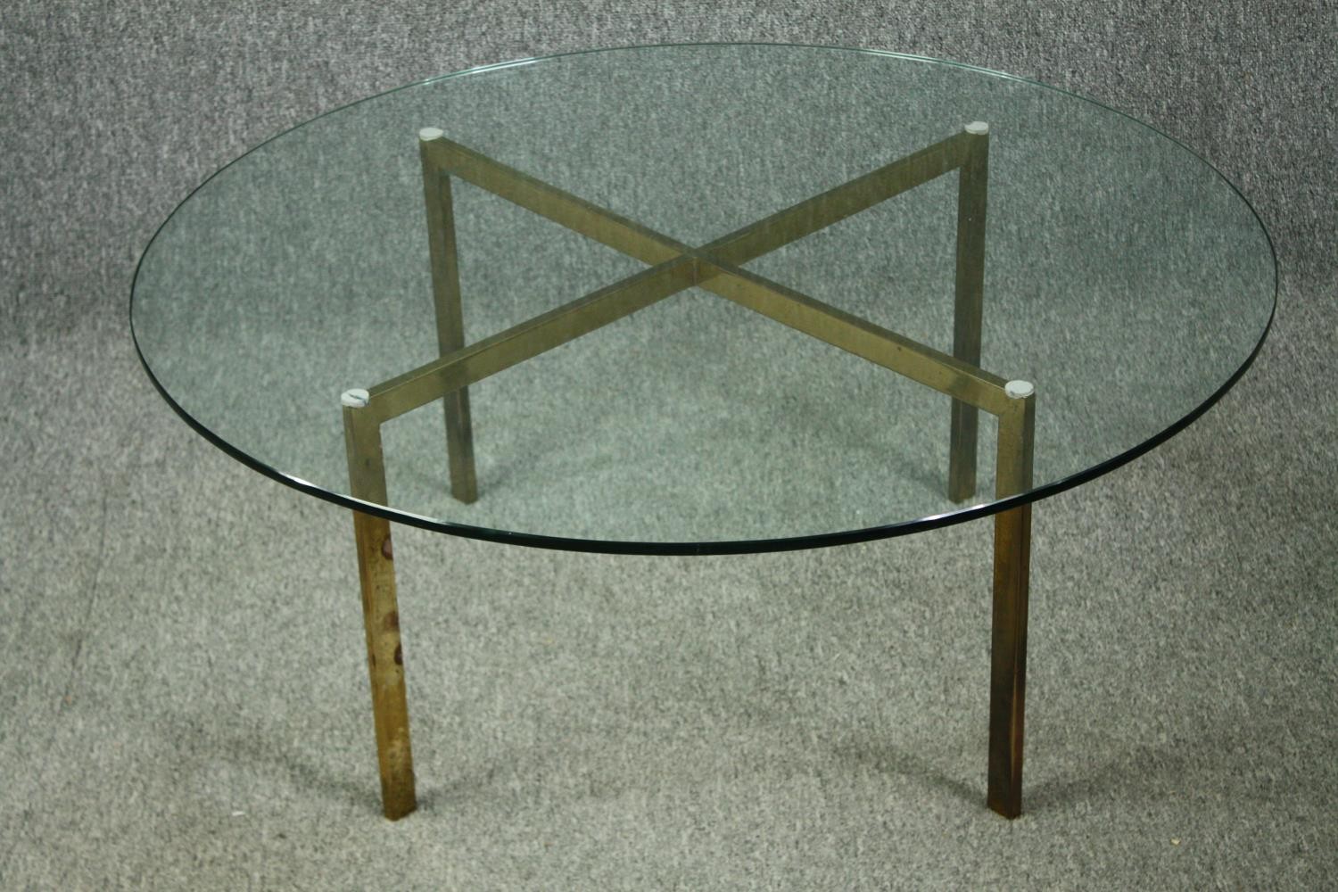 A vintage glass coffee table on brass supports. H.39 Dia.91cm.