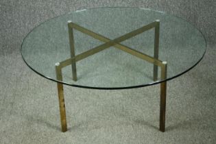 A vintage glass coffee table on brass supports. H.39 Dia.91cm.