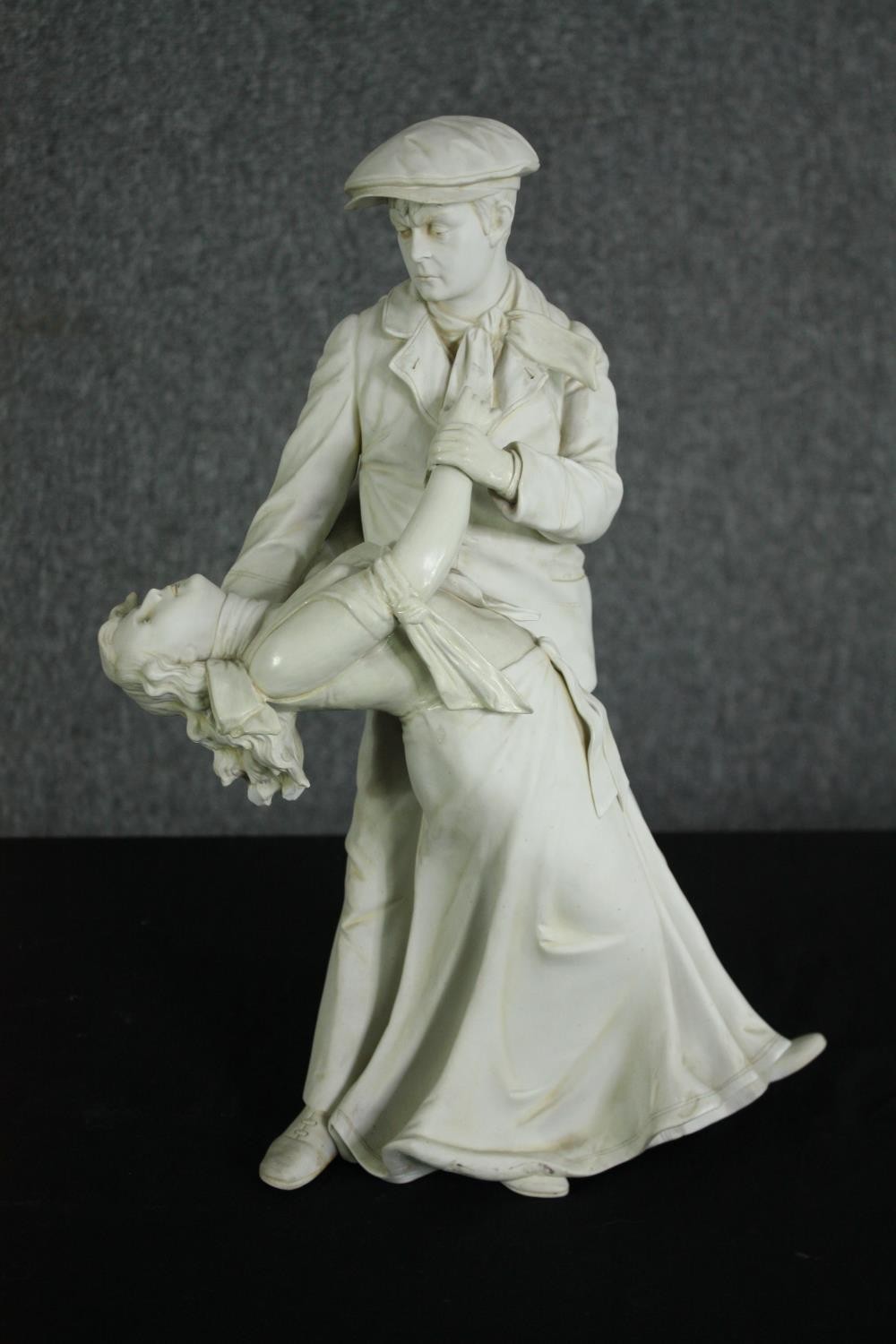 A white bisque porcelain figural group of an early 20th century man and woman dancing. H.39cm.