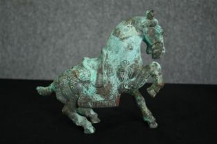 A Chinese Tang style bronzed metal model of a horse, with verdigris patination. H.21cm.