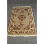 A Chinese style rug, with beige ground. L.163 W.92cm.