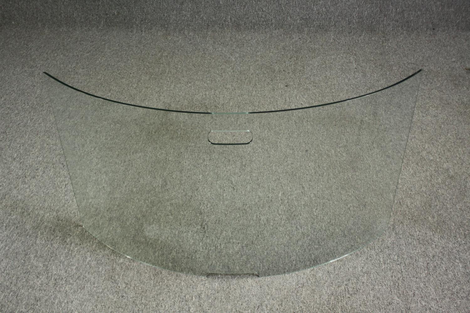 A modern curved glass fire screen. H.55 W.96cm.