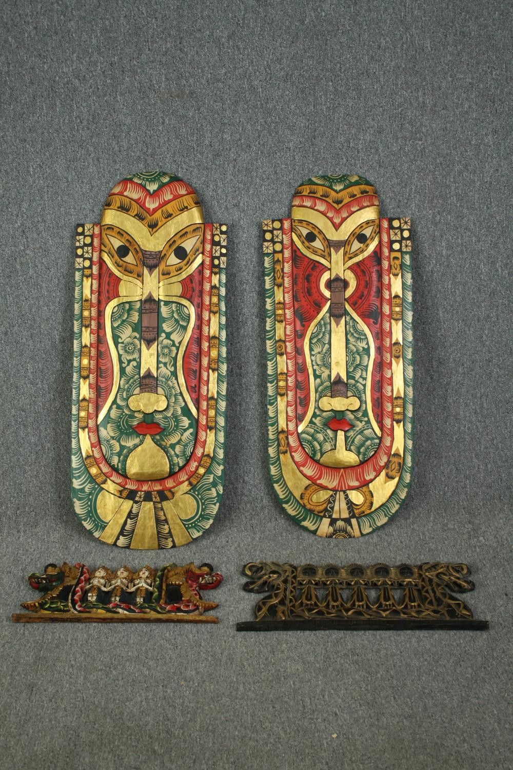 A pair of Indonesian painted head masks, with other smaller associated carvings. L.103 W.42cm. (