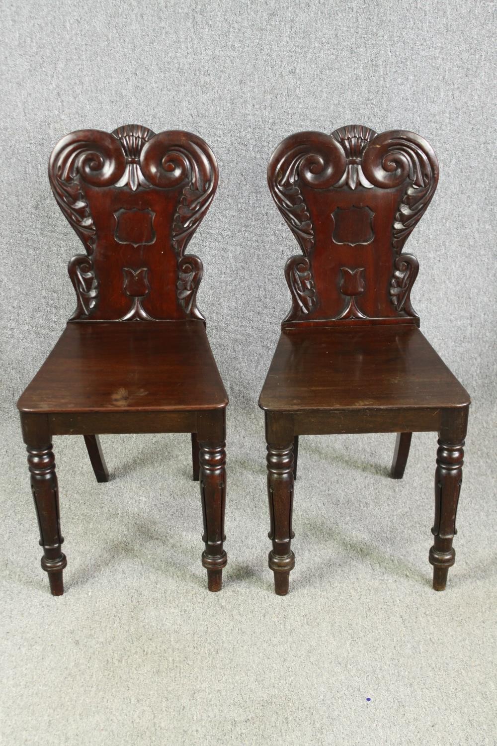 A pair of early Victorian mahogany hall chairs. H.86cm.