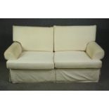 A two seater sofa in ivory upholstery. H.96 W.183 D.95cm.