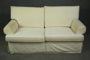 A two seater sofa in ivory upholstery. H.96 W.183 D.95cm.