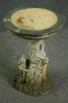 A composition stone pedestal bird bath, in the form of children playing around a tree trunk. H.60